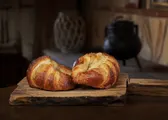 Dos croissants dorados sobre una tabla de madera