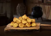 Dulces de coco dorados apilados sobre una tabla de madera