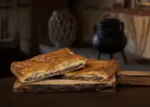 Empanada mediana partida en dos trozos, con el relleno a la vista