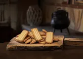 Galletas de nata alargadas y doradas sobre una tabla de madera